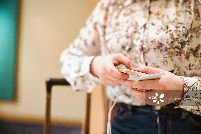 女子使用手机在线办理登机手续图片素材