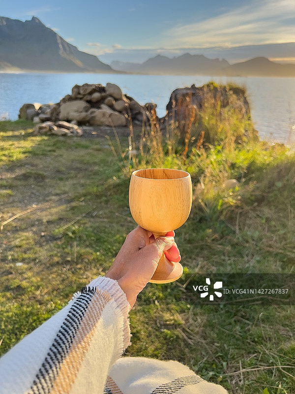 女人在户外手持木杯的POV视角图片素材