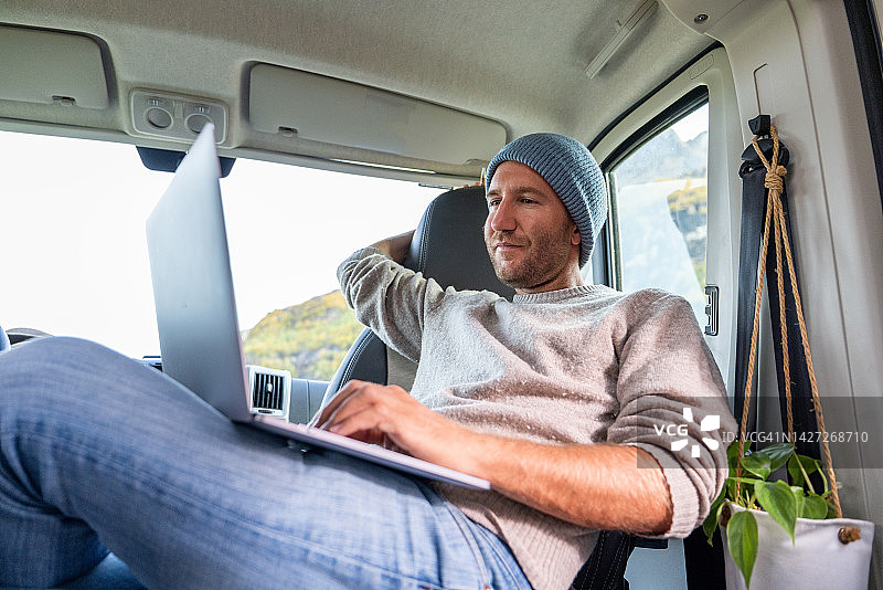 在货车里学习的年轻男人，移动学习概念图片素材
