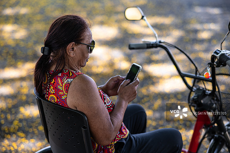 在城市里和她的电动三轮车一起出去玩的老年女士图片素材
