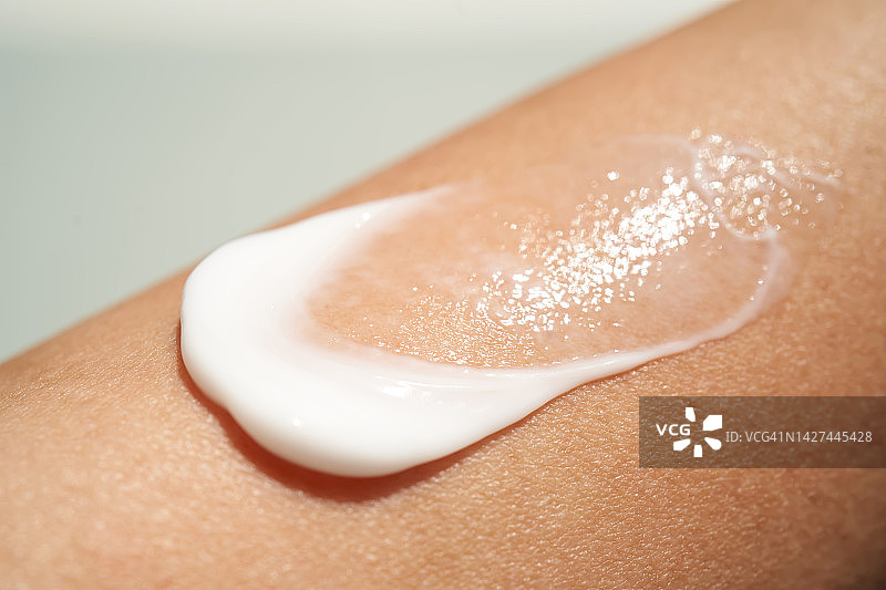 女性皮肤上的白色奶油质地图片素材