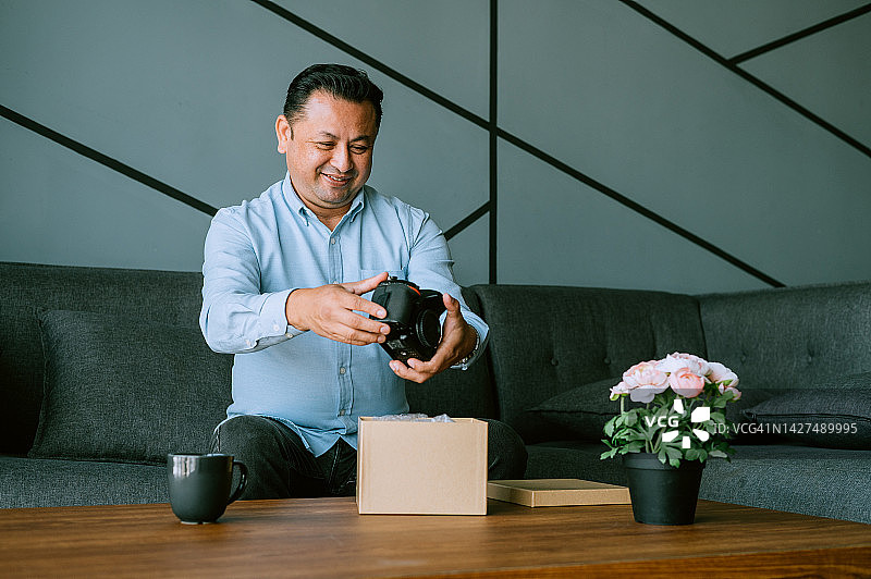 快乐的亚洲男人在家收到包裹图片素材