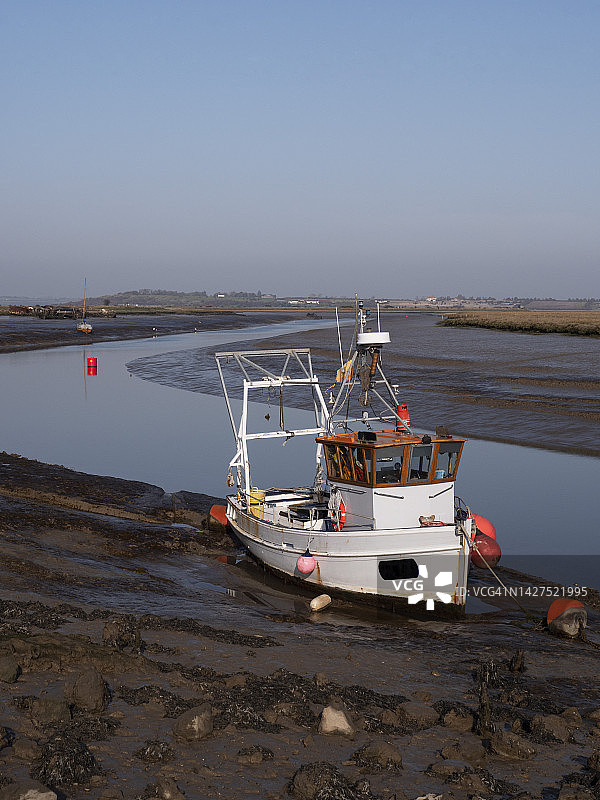 低潮时费弗舍姆小溪泥地上的渔船图片素材