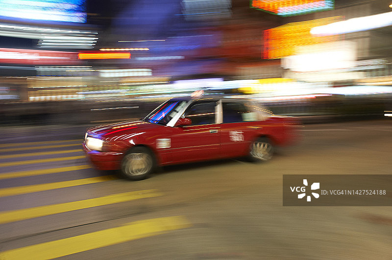 夜晚疾驰的红色香港出租车图片素材