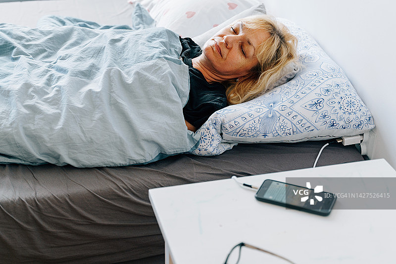 在床上做白日梦的中年妇女图片素材