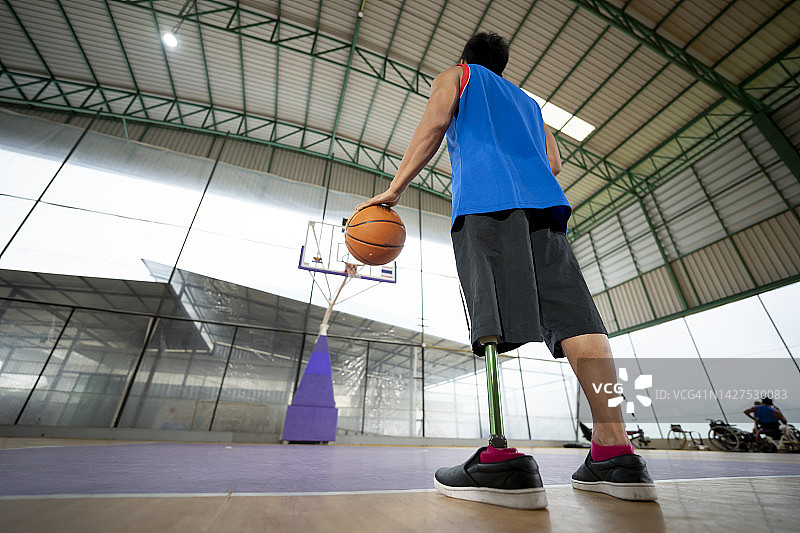 快乐的假肢运动员在篮球场上手持篮球图片素材