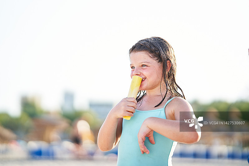 快乐的女孩在夏天户外享受冰淇淋，笑容满面图片素材