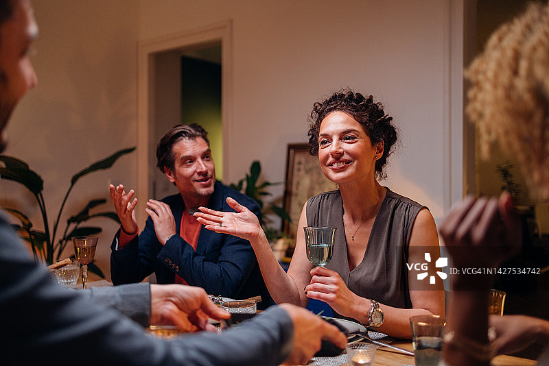 快乐的朋友们在晚餐庆祝活动中玩乐图片素材