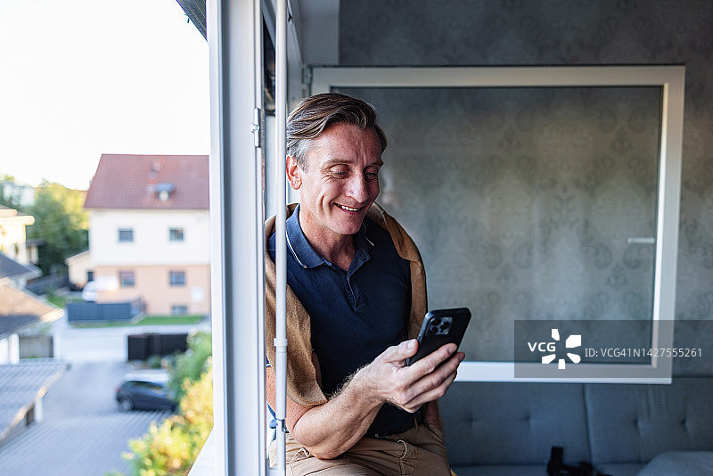 在家使用智能手机的富裕男人图片素材