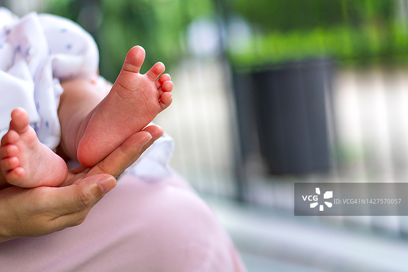 母亲手中的婴儿脚，幸福家庭的概念图片素材