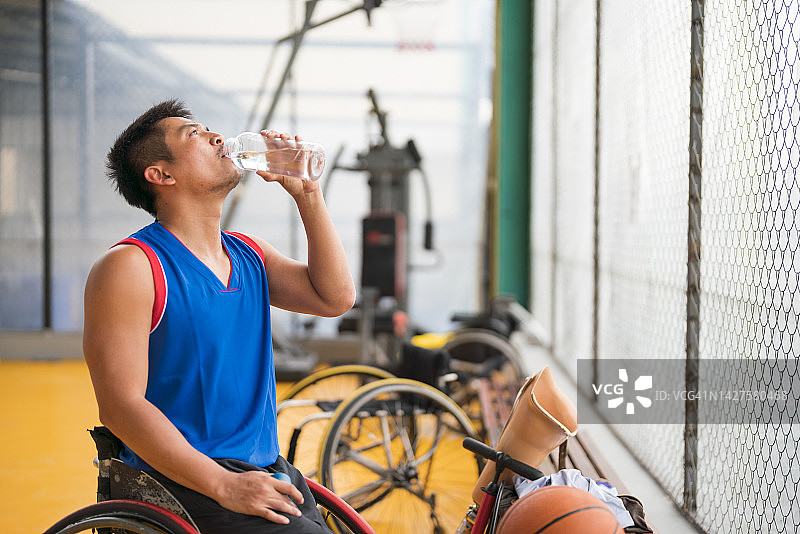 坐在轮椅上休息的年轻截肢男子图片素材