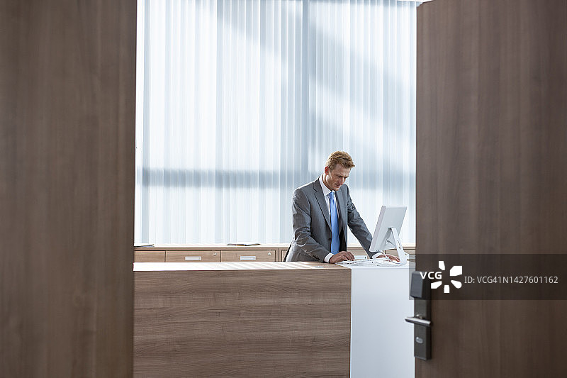 友好的男商人在办公室柜台工作图片素材