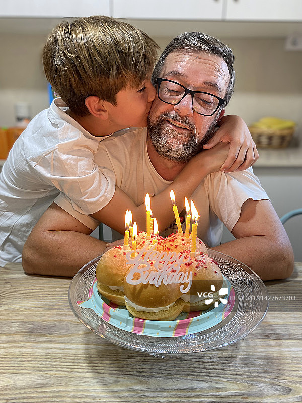 男孩在庆祝生日时亲吻父亲图片素材