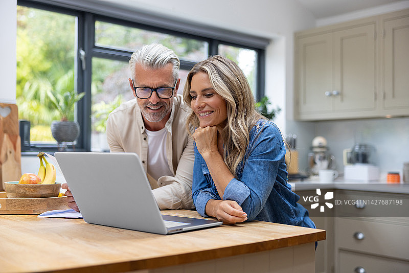 幸福情侣使用笔记本电脑在线支付账单图片素材