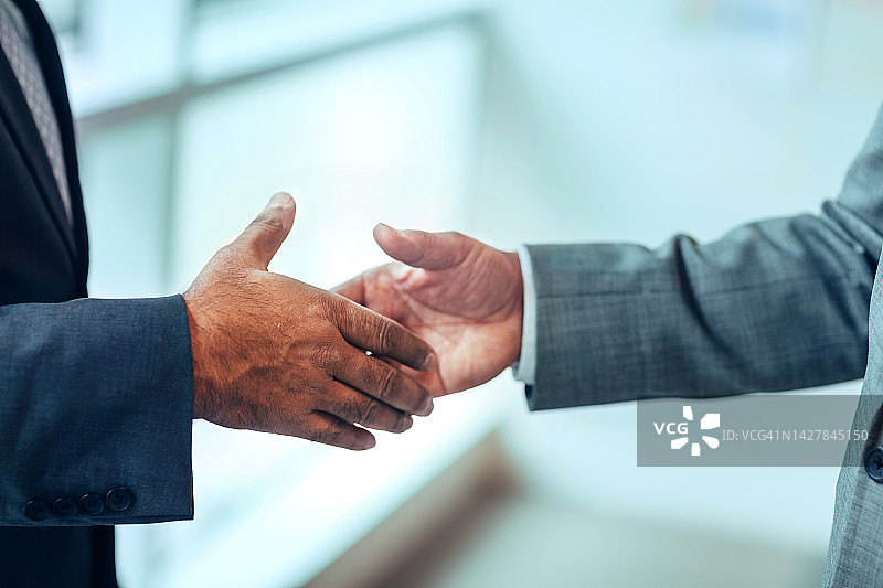 亚裔非裔美国成熟商人准备在明亮的办公室里握手图片素材