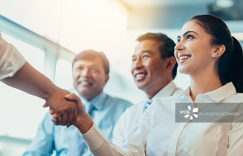 面试成功后与老板和人力资源面试官握手，与多元文化同事在明亮办公室庆祝晋升的中年妇女图片素材