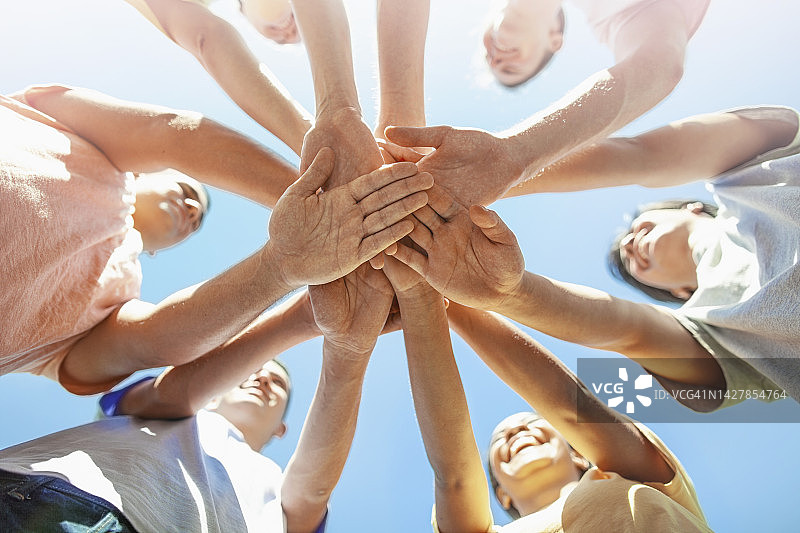 作为环保社会问题志愿者，互相叠手以示社区支持的多种族青年学生图片素材