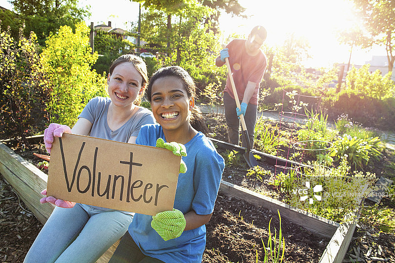 西班牙裔和白人女学生在社区花园做志愿者活动肖像图片素材