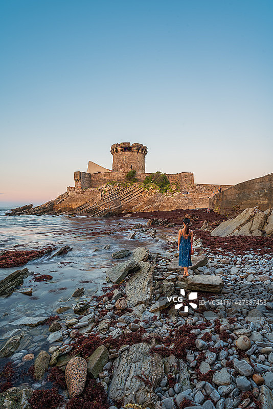 索科阿堡，妇女站在夕阳下的独特滩涂海滩上图片素材