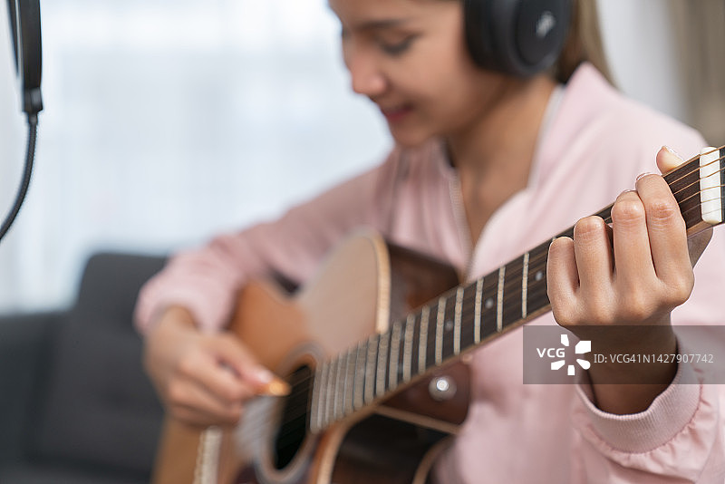 在沙发上弹吉他的女孩图片素材