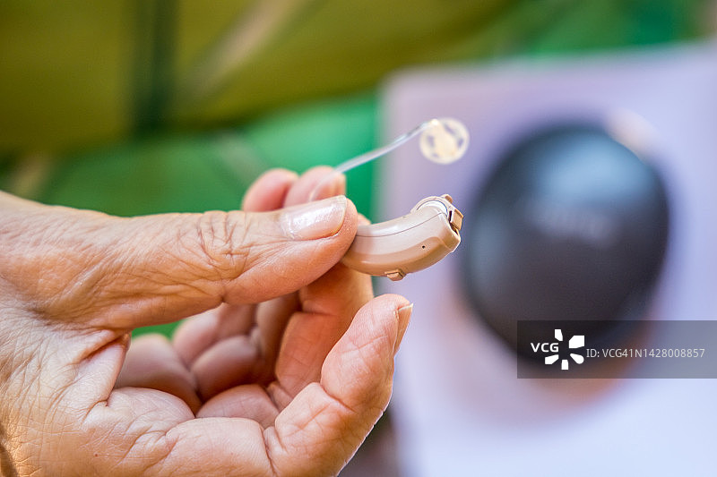 老年妇女佩戴现代助听器特写图片素材