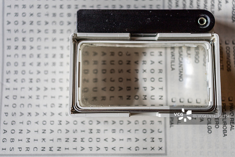 纵横字谜上的放大镜特写图片素材