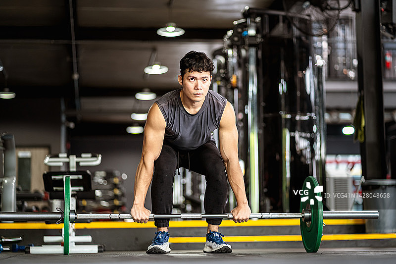 亚洲男人在健身房内做举重练习图片素材