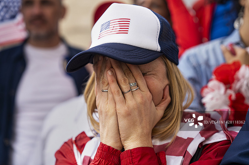 在美利坚合众国国家足球队比赛中，年轻失望的女人用手捂住脸图片素材