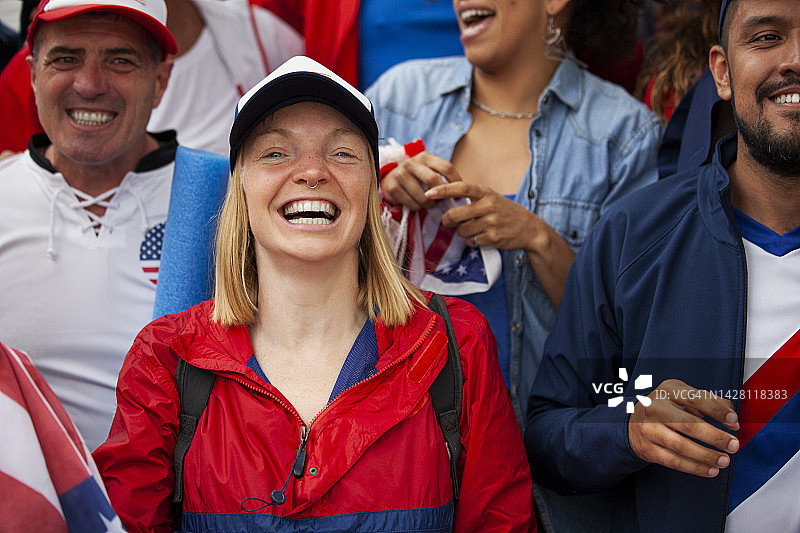 快乐的年轻美国女足球迷在体育场为美国国家队欢呼图片素材