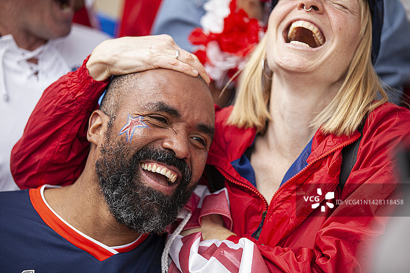 两名年轻快乐的美国足球爱好者在体育场为国家队足球比赛欢呼图片素材