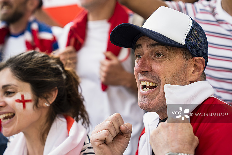 脖子上围着英国国旗，为国家队欢呼的英国足球迷图片素材