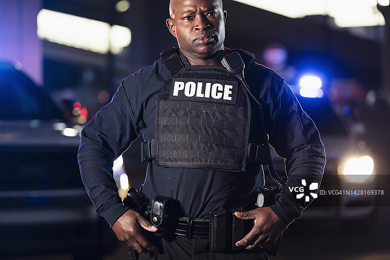 表情严肃的非裔美国警察，警灯闪烁图片素材