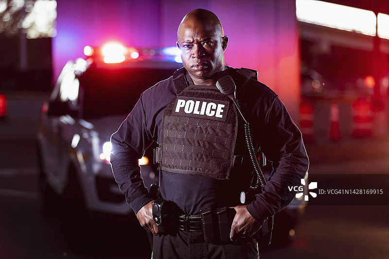 表情严肃的非裔美国警察，警灯闪烁图片素材