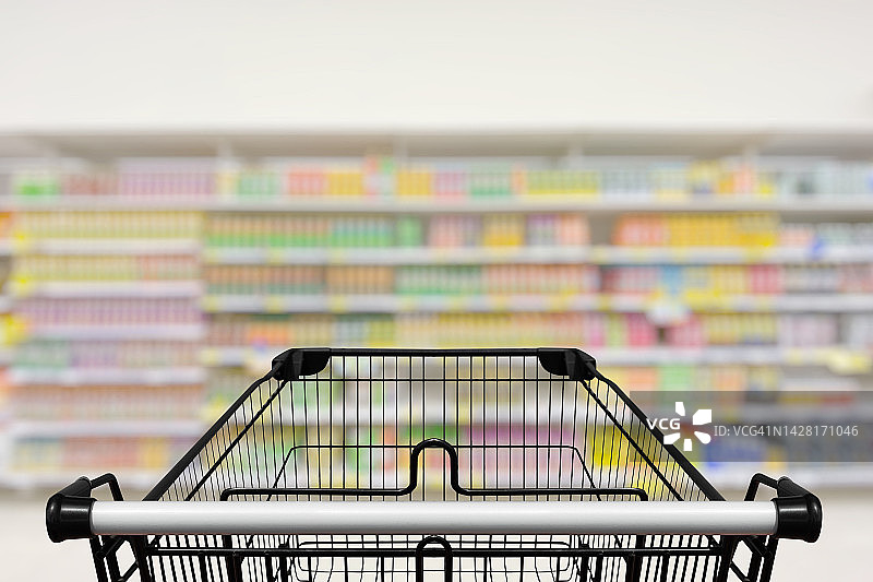 超市通道中的购物车，模糊背景图片素材