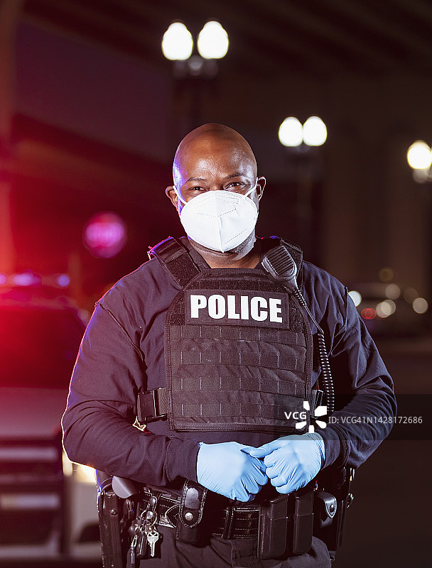 戴着口罩的非裔警察在夜晚执勤图片素材