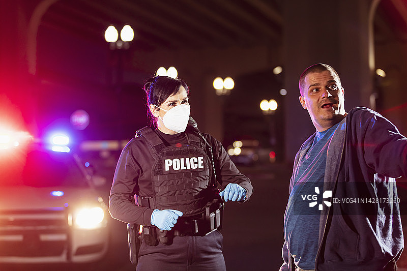 戴着口罩的女警察夜间审问男子图片素材
