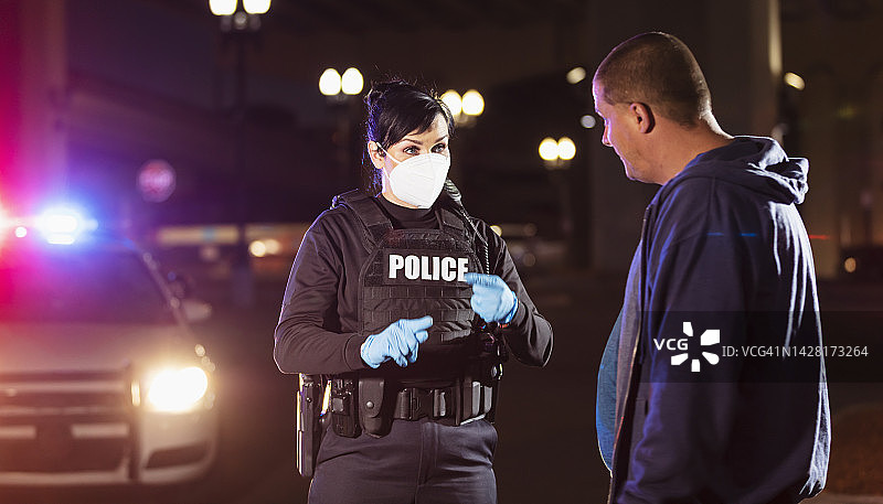 戴着口罩的女警察夜间审问男子图片素材