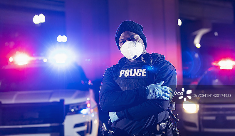 戴着口罩的非裔警察在夜晚执勤图片素材