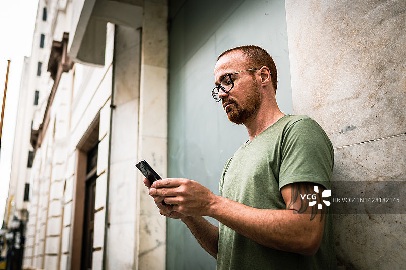 在街上使用手机的严肃男人图片素材