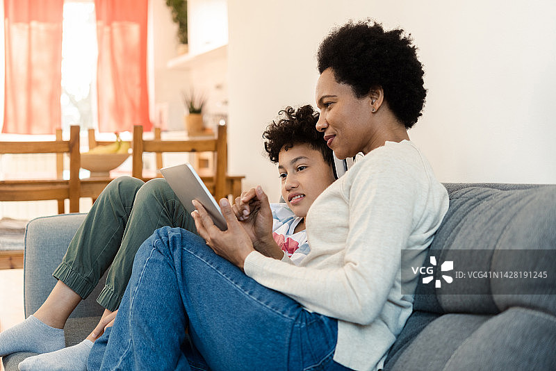 男孩和他的妈妈在家享受并在线学习图片素材
