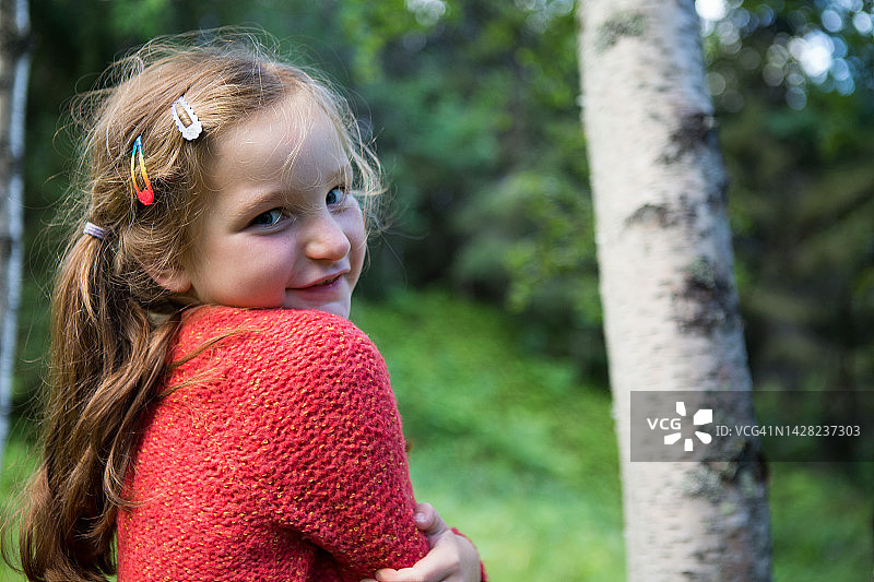 在挪威森林中拥抱自己的美丽女孩肖像图片素材