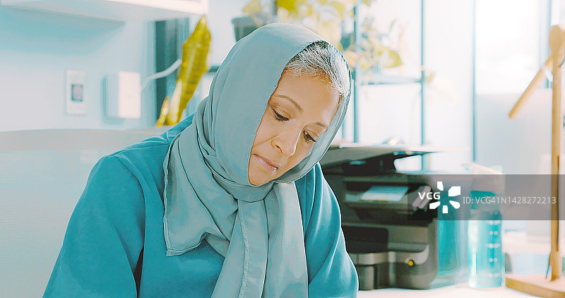 戴头巾的穆斯林老年妇女在办公室思考工作，态度认真。从事规划职业和退休策略的伊斯兰商业雇员或年长经理图片素材