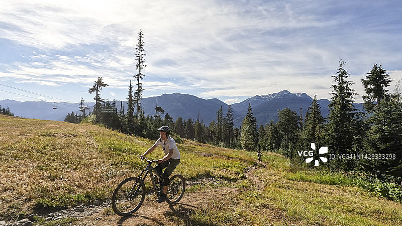 年轻男女在狭窄的小路上骑山地自行车图片素材