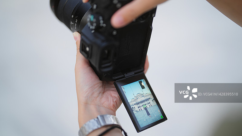 年轻女游客和社交媒体网红在旅行期间参观清真寺时被拍摄图片素材