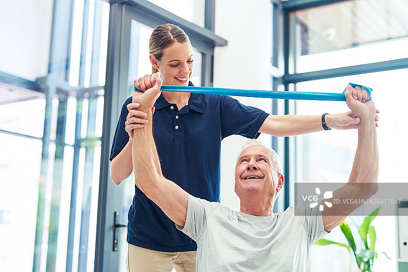 理疗：老年男子使用臂带进行物理治疗和运动训练图片素材