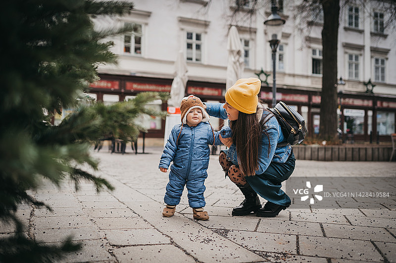 母亲和儿子站在圣诞树旁图片素材