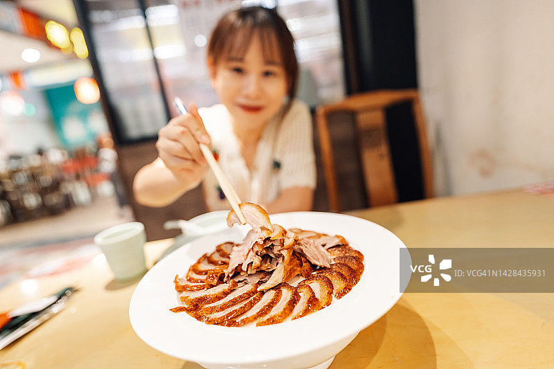 用筷子吃烤鸭的女人图片素材