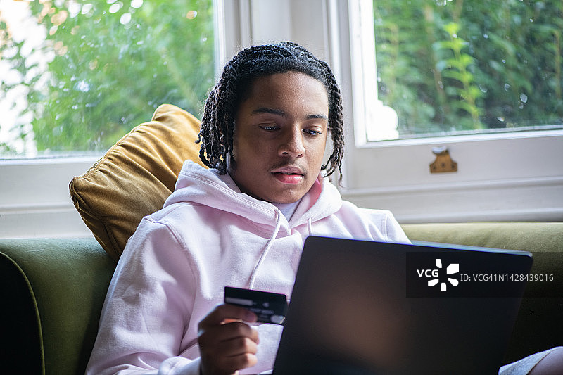 年轻男人用信用卡在网上购物图片素材