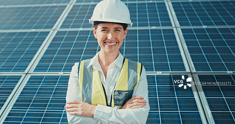 快乐的工程女性肖像，手持太阳能电池板，设计用于清洁可再生太阳能。工程师以可持续发展工作为荣，致力于环保光伏发电图片素材