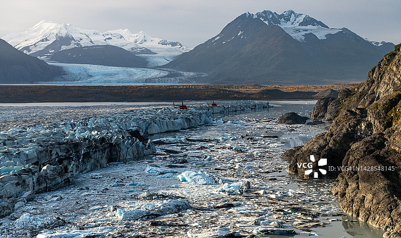 阿拉斯加克尼克冰川湖边缘与红色直升机和冰山图片素材